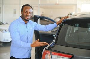 Happy Car Buyer, New Car Owner Concept. Portrait Of Excited Young African American Guy In Dealership Showroom photo