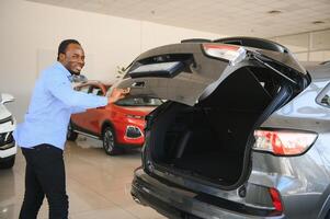 Happy Car Buyer, New Car Owner Concept. Portrait Of Excited Young African American Guy In Dealership Showroom photo