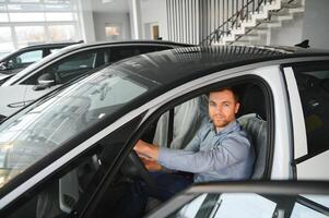 joven hombre, de venta eléctrico carros en el sala de exposición. concepto de comprando Respetuoso del medio ambiente coche para familia foto