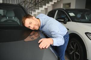 un contento hombre elige un nuevo eléctrico coche a un coche concesión. el concepto de comprando un ecológico coche foto