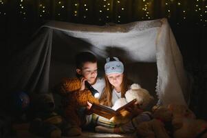 Little children reading bedtime story at home. photo