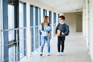 Happy school kids in corridor at school. Learning concept. photo