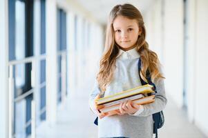 Portrait of a beautiful girl with books at school. Learning concept. photo