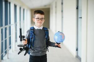 Schoolboy with schoolbag and books in the school. Education concept. Back to school. Schoolkid going to class. Stylish boy with backpack. Boy ready to study. photo