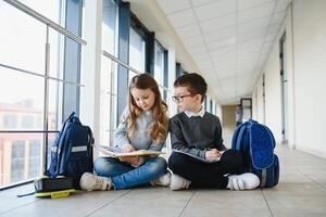 School kids with books together in corridor. Conception of education photo