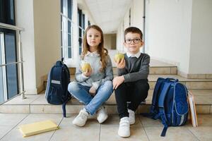 colegio niños con libros juntos en corredor. concepción de educación foto