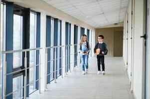 Happy school kids in corridor at school photo