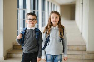 contento colegio niños en corredor a escuela. aprendizaje concepto. foto