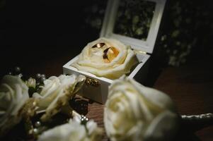 gold rings and a beautiful bridal bouquet of roses on the background. details, wedding traditions. close-up, macro. photo