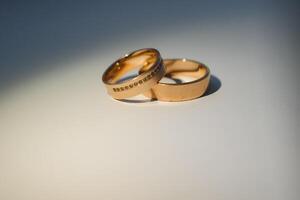 Elegant wedding rings for the bride and groom on a black background with highlights, macro, selective focus. photo