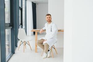 masculino médico cerca recepción escritorio en clínica foto