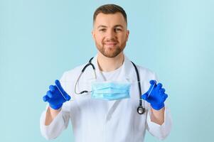 Male doctor in medical mask on color background photo