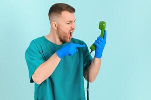 doctor with phone on a blue background. doctor call concept photo