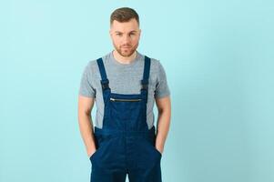 Close-up portrait of his he nice attractive cheerful cheery content guy repairer craftsman isolated over blue color background. photo