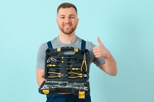 Craftsmen or electrician man over isolated blue background giving a thumbs up gesture photo