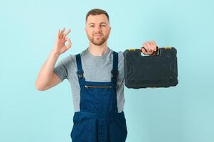 Craftsmen or electrician man over isolated blue background showing an ok sign with fingers photo