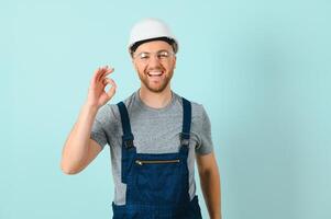 Craftsmen or electrician man over isolated blue background showing an ok sign with fingers photo