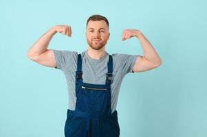 Close-up portrait of his he nice attractive cheerful cheery content guy repairer craftsman isolated over blue color background. photo