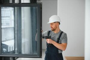 Professional master at repair and installation of windows, at work. photo