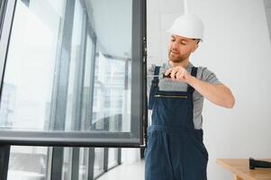 Construction worker installing window in house photo