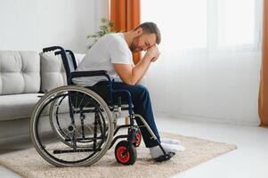 Depression and loneliness in disabled man. Elderly man in wheelchair crying indoors photo