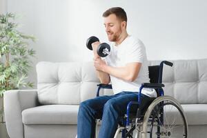 Man Disabled. Sports for Disabled. Male in Wheelchair with Dumbbells in Hands. Man with Dumbbells in Hands. Father Disabled Do Spotting. Sport at Apartment. Health Concept. Healthy Lifestyle. photo
