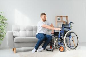 Disabled young black guy trying sit down. photo