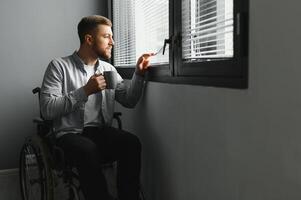 Businessman sitting on wheelchair at hospital. Sad disabled at the hospital photo