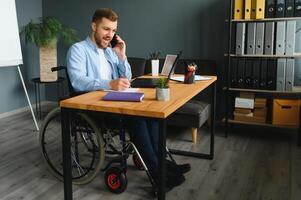 Man in wheelchair at home or in office photo