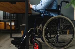 Man in wheelchair at home or in office. photo