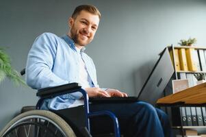 Man in wheelchair at home or in office. photo