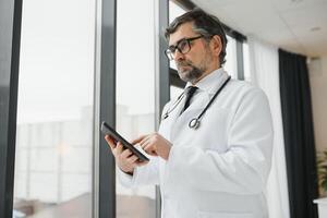 Remote medical consultation. A male doctor consults a woman has a video call conference computer monitor sitting in a clinic office photo