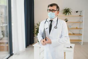 male doctor with medical face mask and a stethoscope at clinic photo