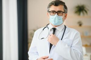 retrato de cuidado de la salud obrero. imagen de mayor masculino médico vistiendo laboratorio Saco y en pie a privado clínica foto