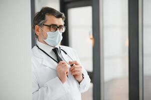 retrato de medio años médico vistiendo protector mascarilla. corona virus concepto. foto