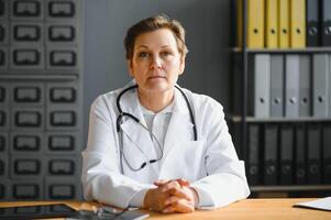 Portrait of senior female doctor in her office. photo