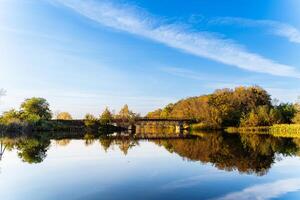 A Tranquil Lake with a Scenic Bridge in the Background. A lake with a bridge in the background photo