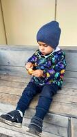 A Little Boy Enjoying a Peaceful Moment on a Wooden Bench. A little boy sitting on a wooden bench photo