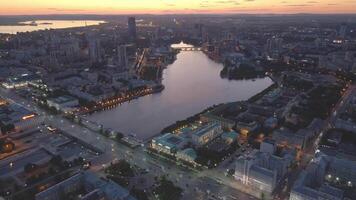 Jekaterinenburg Bij schemer rivier- iset metropolis temidden van urals moderniteit voldoet aan geschiedenis. metropolis canvas van hoogbouw gebouwen en cultureel diepte van bovenstaand de stad hart beats ritme vooruitgang traditie. video