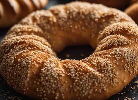 ai generado turco rosquilla simit con sésamo semillas en un negro antecedentes foto