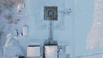 Hubschrauberlandeplatz schneebedeckt Feld umgeben durch Wald Nord Einsamkeit Hubschrauberlandeplatz Symbol Luft Mobilität eisig Natur. Hubschrauberlandeplatz verbinden Fernbedienung schneebedeckt Landschaften Punkt von Verbindung im Welt von Eis und Schnee. video