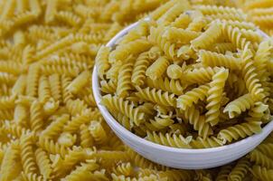 Dried Fusilli Pasta in Bowl for Cooking photo