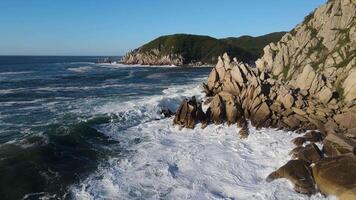 Slow motion view of powerful storm waves rolling onto the rocky shore video