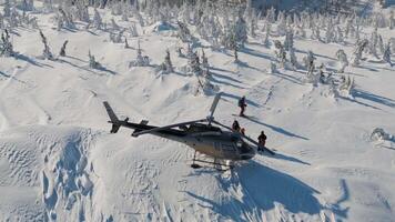 In snow helicopter aerial top view against forest mountains backdrop Helicopter snow facing chill majestic mountains. Helicopter snow gateway extreme northern nature Adventure in north exploring. video