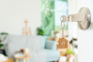 Moving house, relocation. The key was inserted into the door of the new house, inside the room was a cardboard box containing personal belongings and furniture. move in the apartment, banner photo