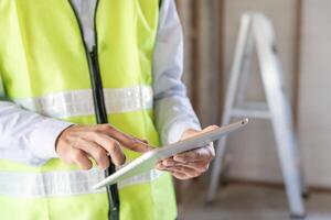 inspector o ingeniero es inspeccionando construcción y calidad garantía nuevo casa utilizando un tableta. ingenieros o arquitectos o contactor trabajo a construir el casa antes de entrega eso terminado a el dueño de casa foto