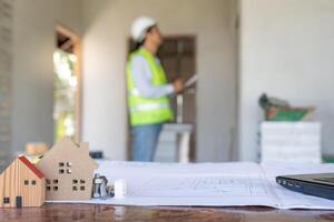 inspector o ingeniero es inspeccionando construcción y calidad garantía nuevo casa utilizando un azul impresión. ingeniero o arquitectos o contactor trabajo a construir el casa antes de entrega eso terminado a el dueño de casa foto