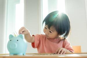 ahorrar dinero. niños poniendo monedas para ahorrar. riqueza, finanzas, seguros, inversiones, educación, futuro, planificar la vida, aprender, banca, familia, salud, salud y seguros de accidentes. foto