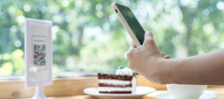 Woman use smartphone to scan QR code to pay in cafe restaurant with a digital payment without cash. Choose menu and order accumulate discount. E wallet, technology, pay online, credit card, bank app. photo