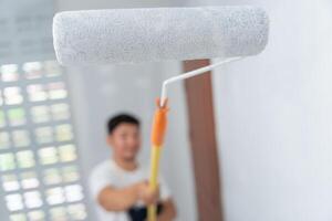 painter man, brush in hand for products to restore and paint the wall, indoor the building site of a house, wall during painting, renovation, painting, contractor, Architect, construction worker photo